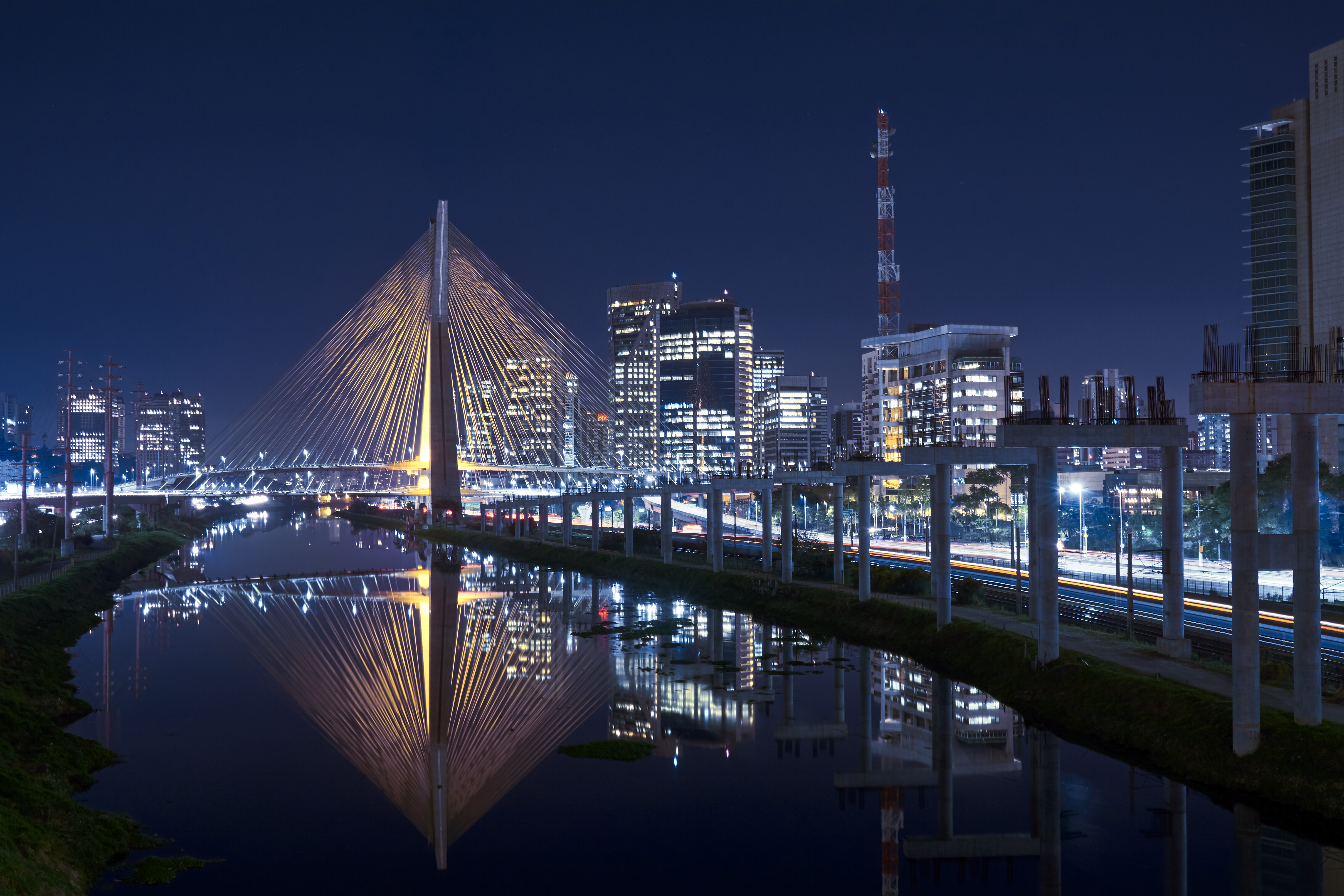 a bridge over a body of water with a city in the background