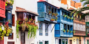 a row of colorful buildings with plants on balconies