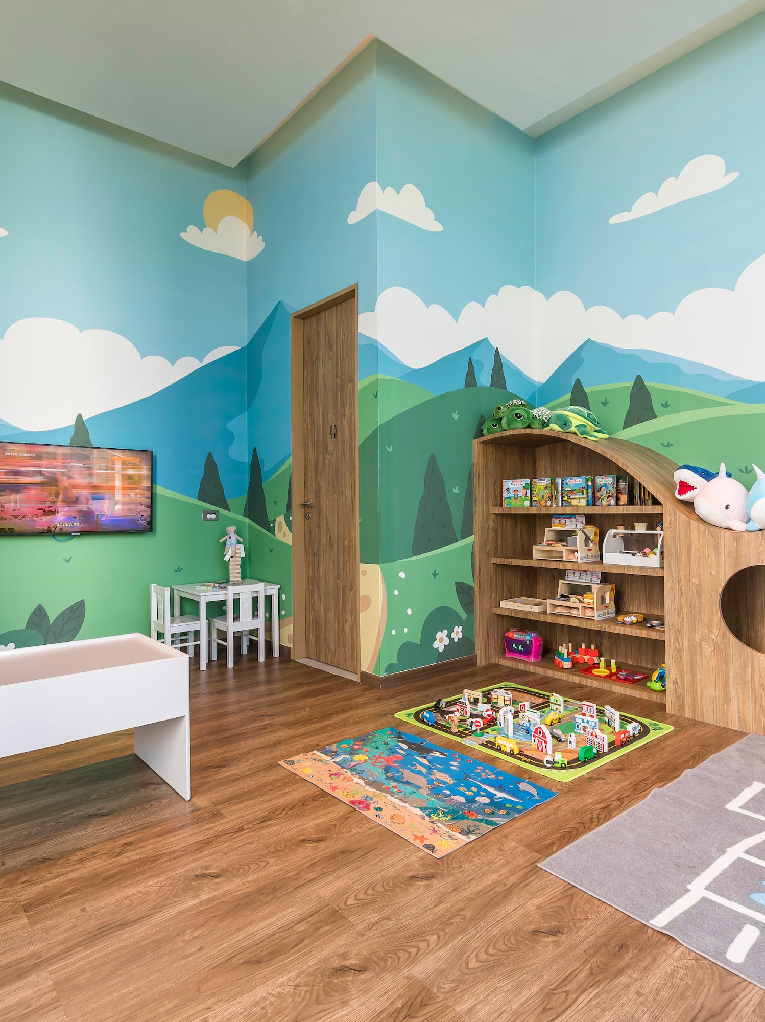 a room with a playroom with a playroom and a tv