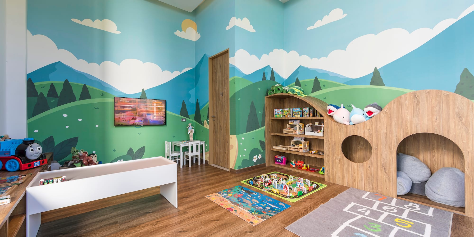 a room with a playroom with a playroom and a tv