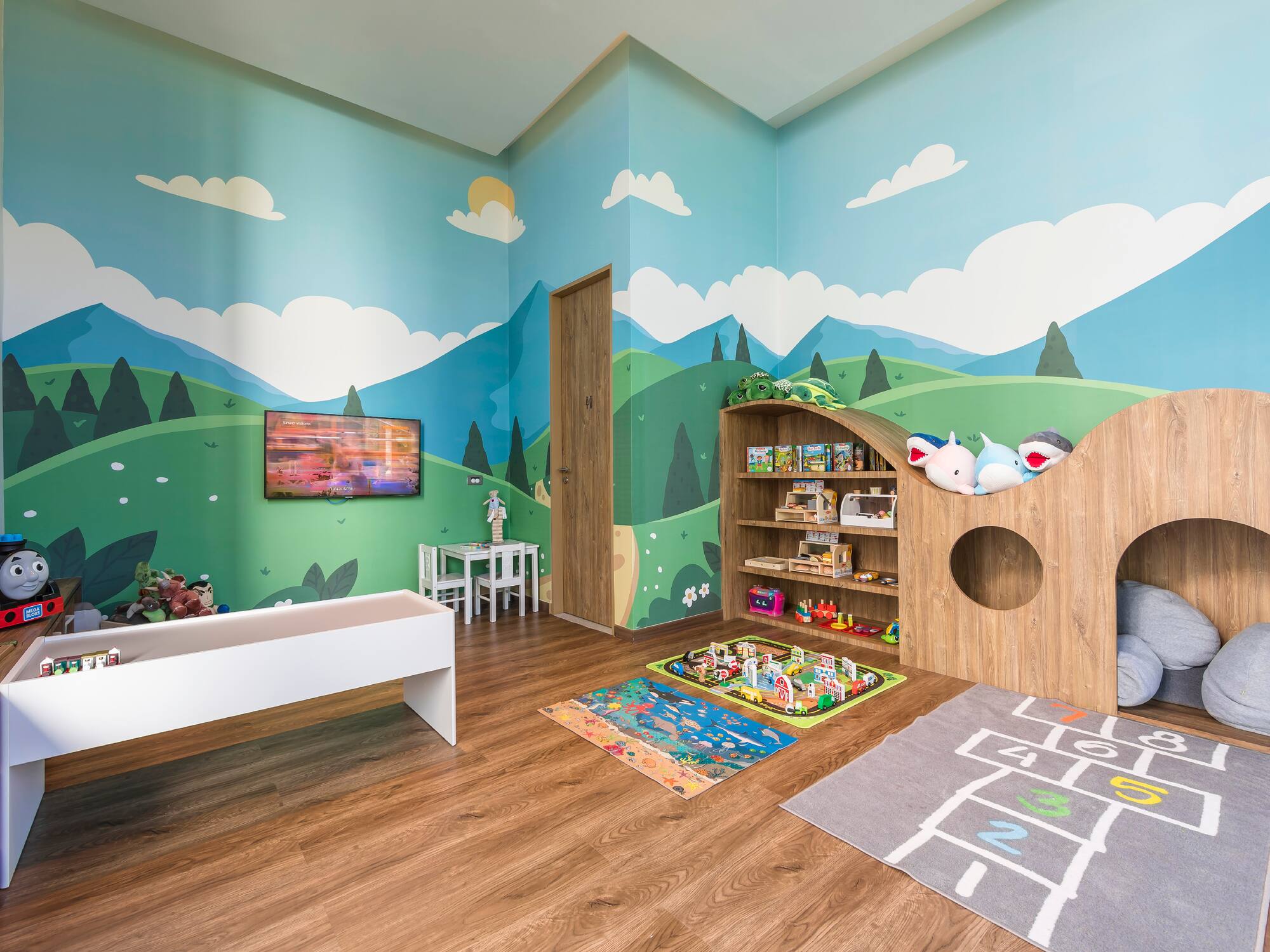 a room with a playroom with a playroom and a tv