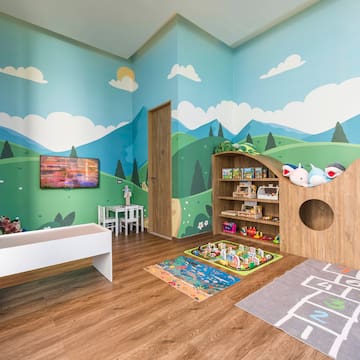 a room with a playroom with a playroom and a tv