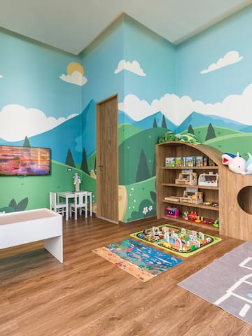 a room with a playroom with a playroom and a tv
