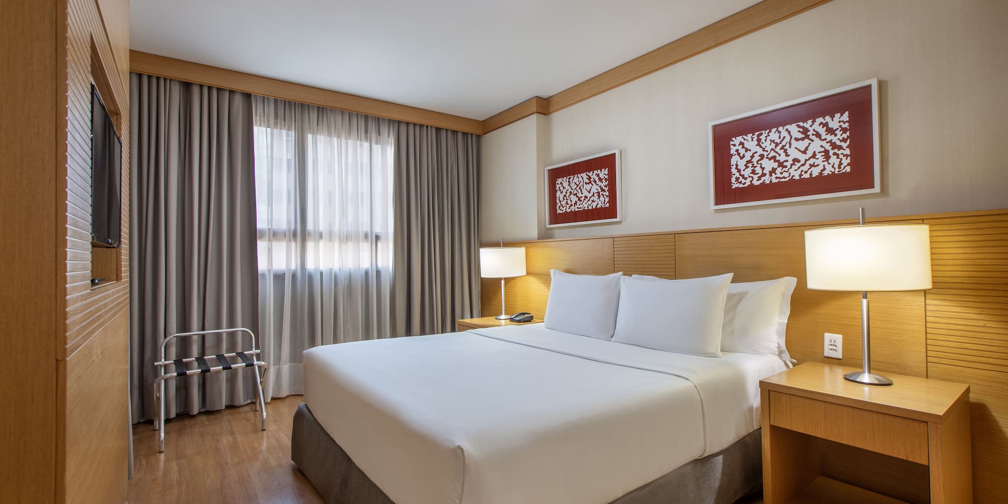 a bed with white sheets and a wood floor