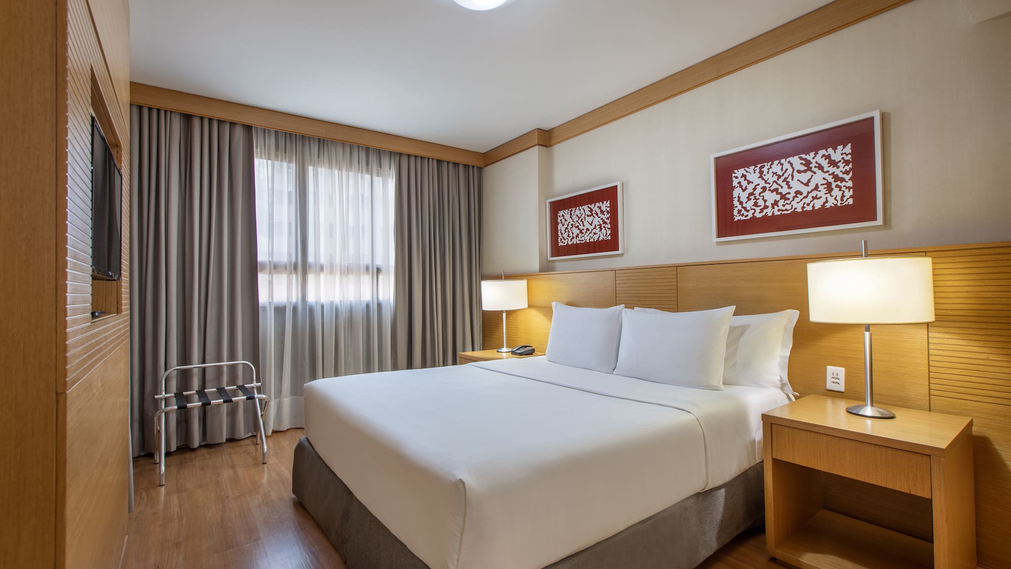 a bed with white sheets and a wood floor