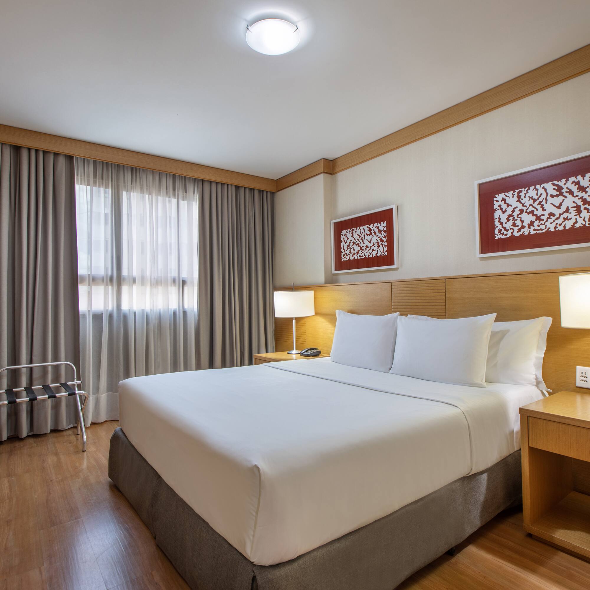 a bed with white sheets and a wood floor