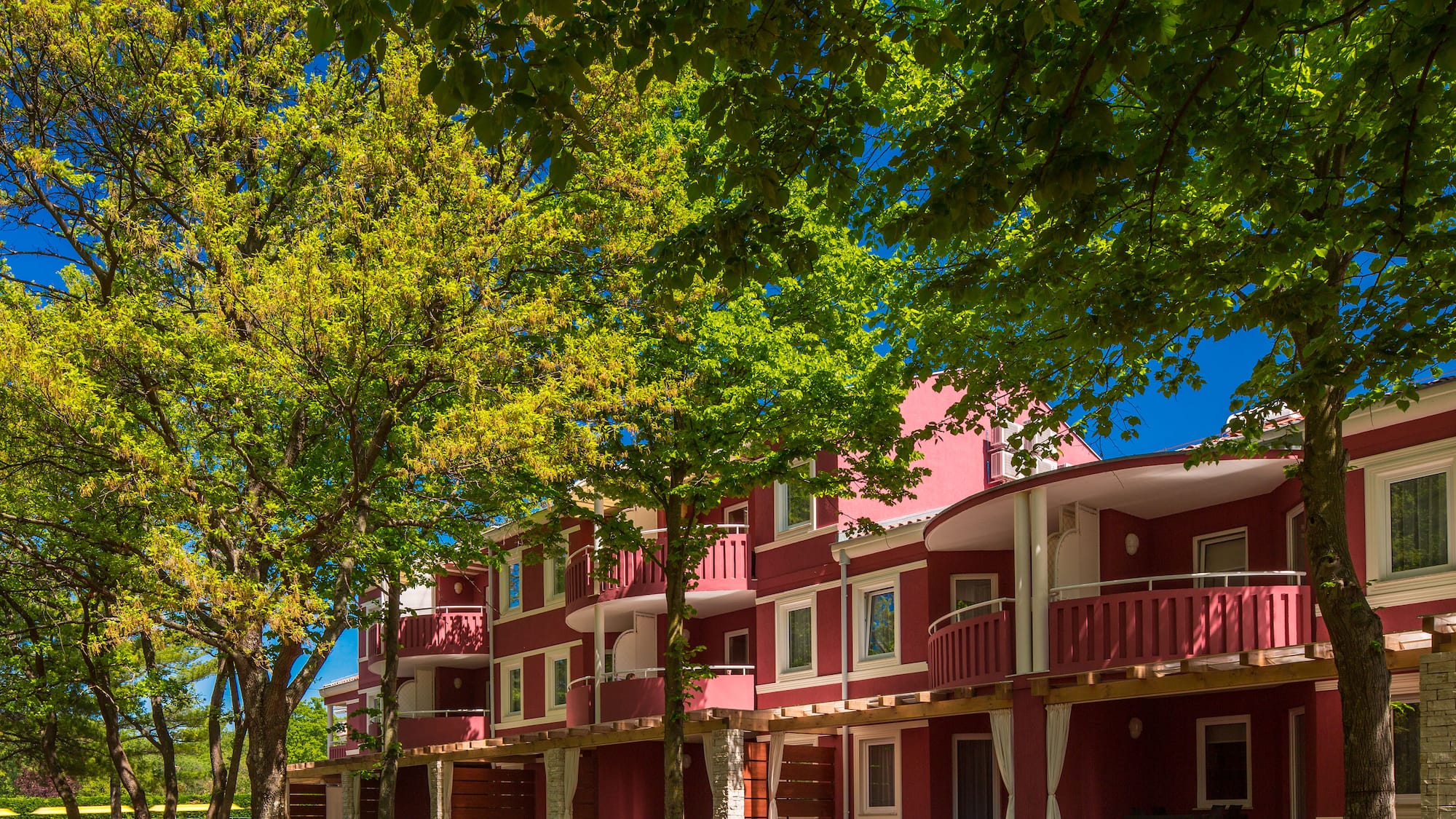 a row of red buildings with trees