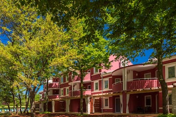 a row of red buildings with trees