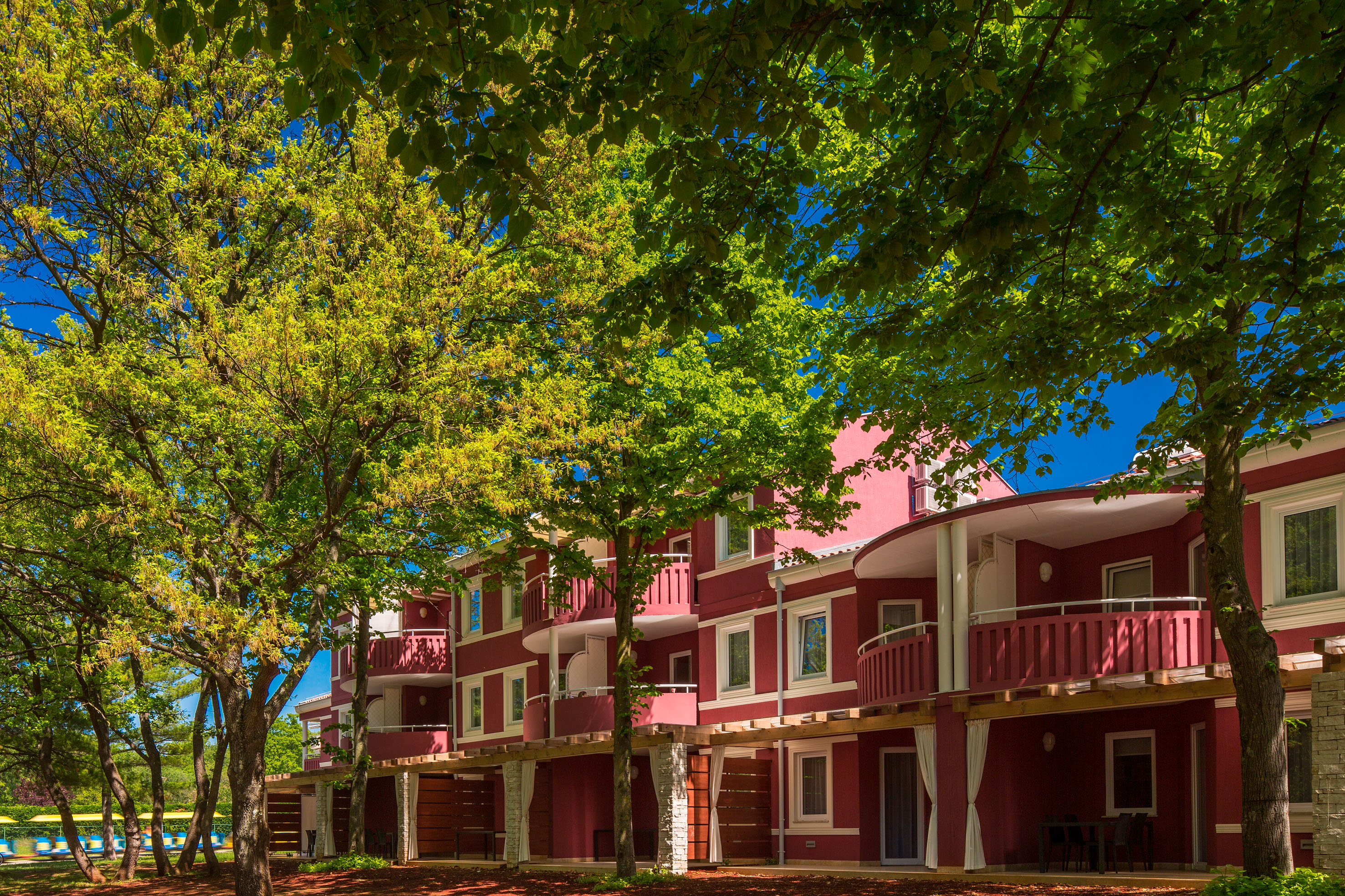 a row of red buildings with trees