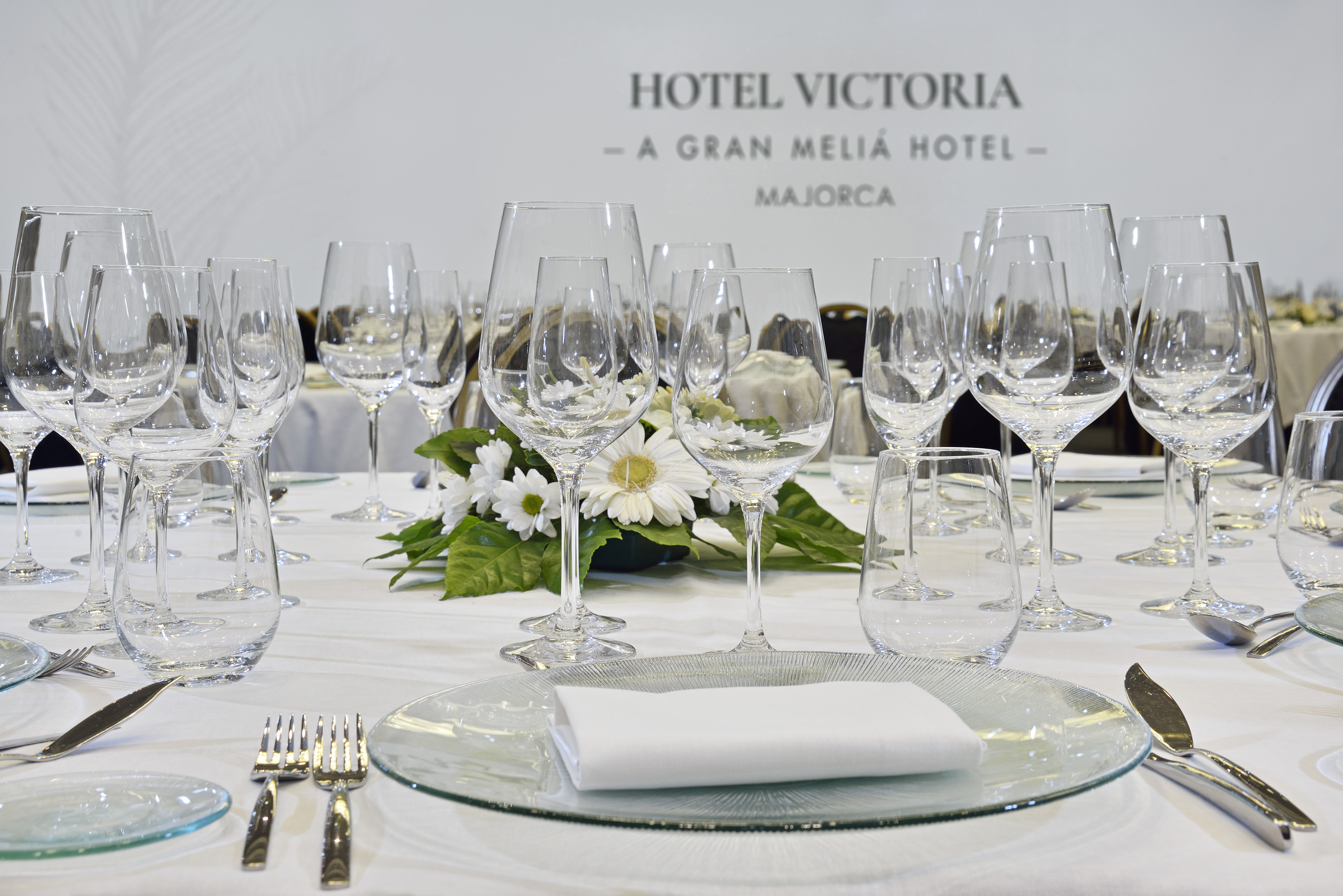 Dining table set with glassware, cutlery, flowers at Hotel Victoria Majorca.