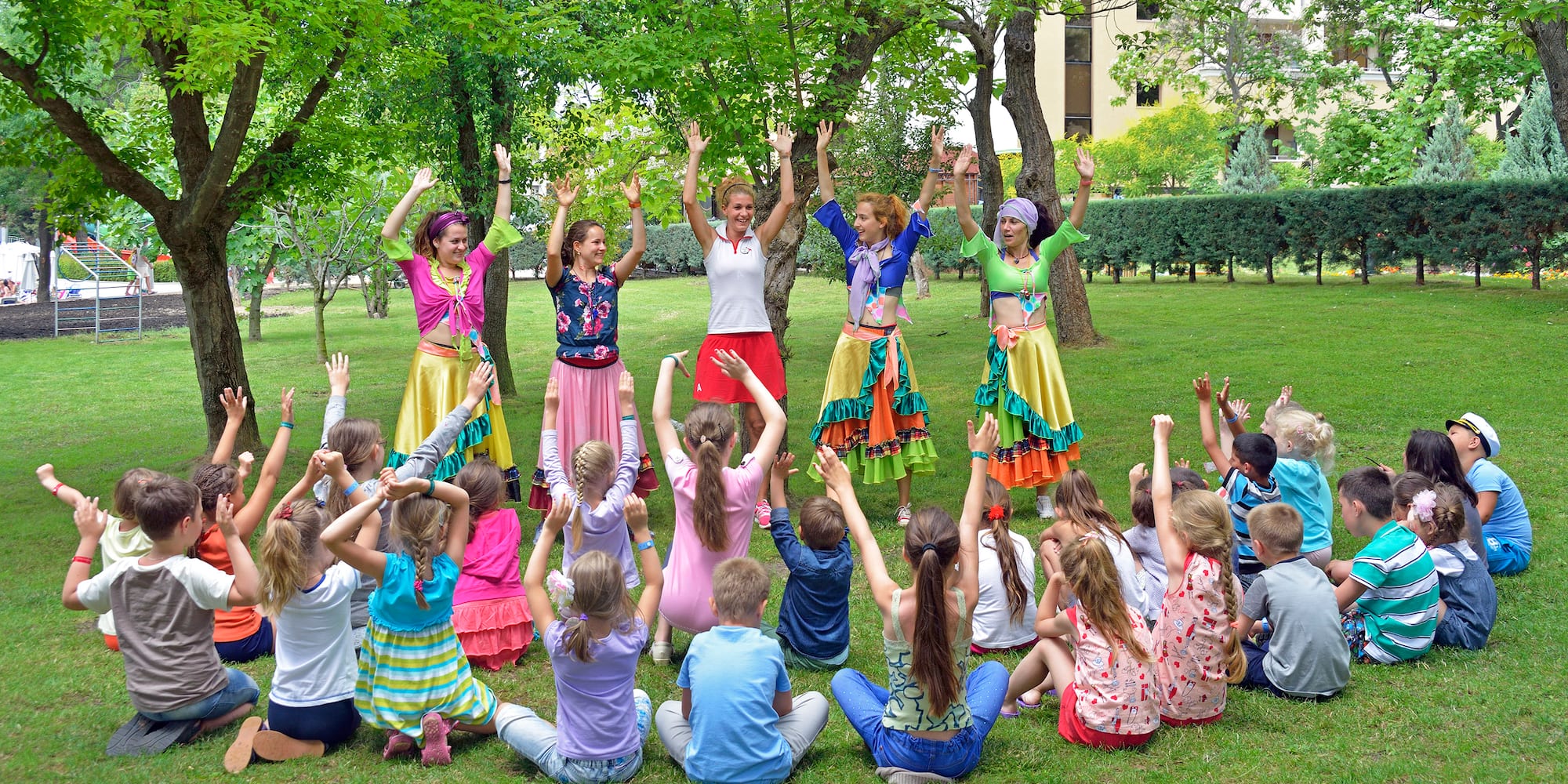 a group of people in colorful clothes raising their hands