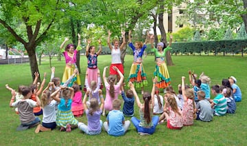 a group of people in colorful clothes raising their hands