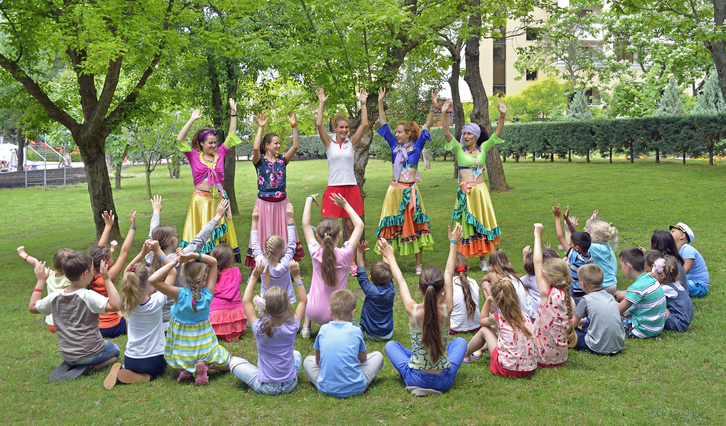 a group of people in colorful clothes raising their hands