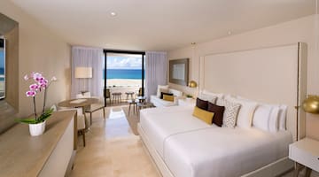 a room with a large bed and a table and chairs