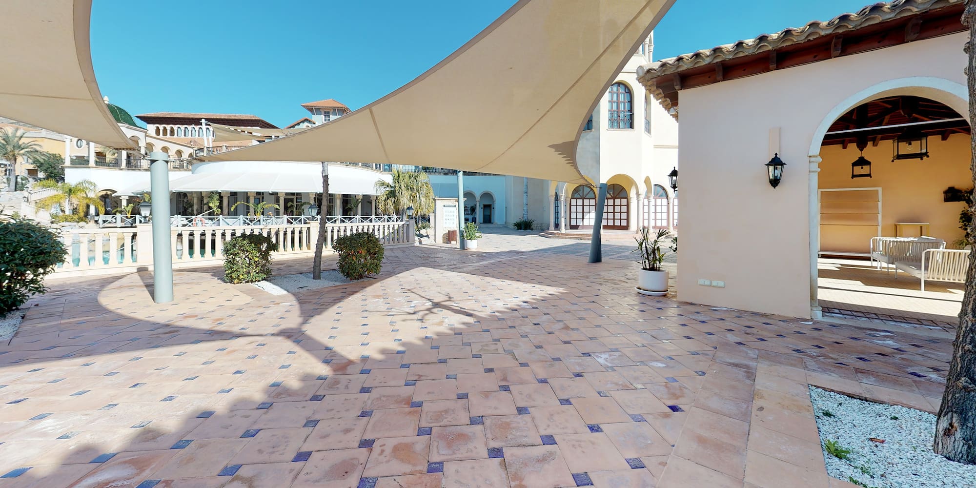 a patio with a white roof and a building