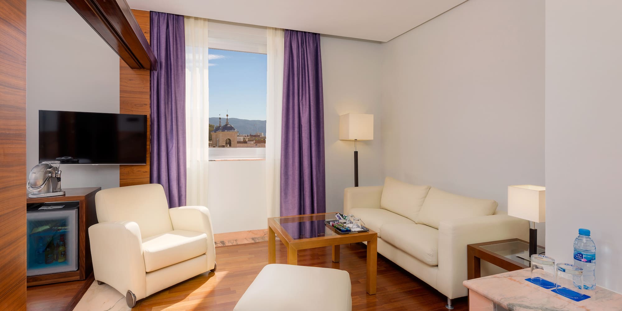 a living room with purple curtains and white furniture