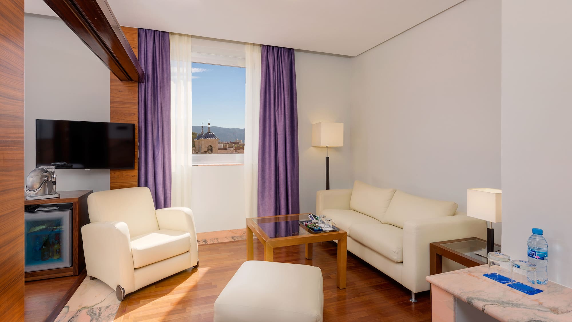 a living room with purple curtains and white furniture