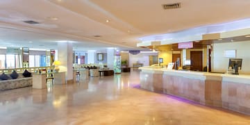 a large lobby with a reception desk and chairs