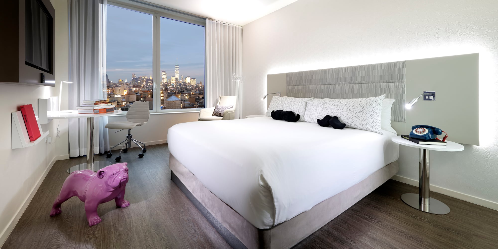 a bedroom with a large bed and a pink dog statue