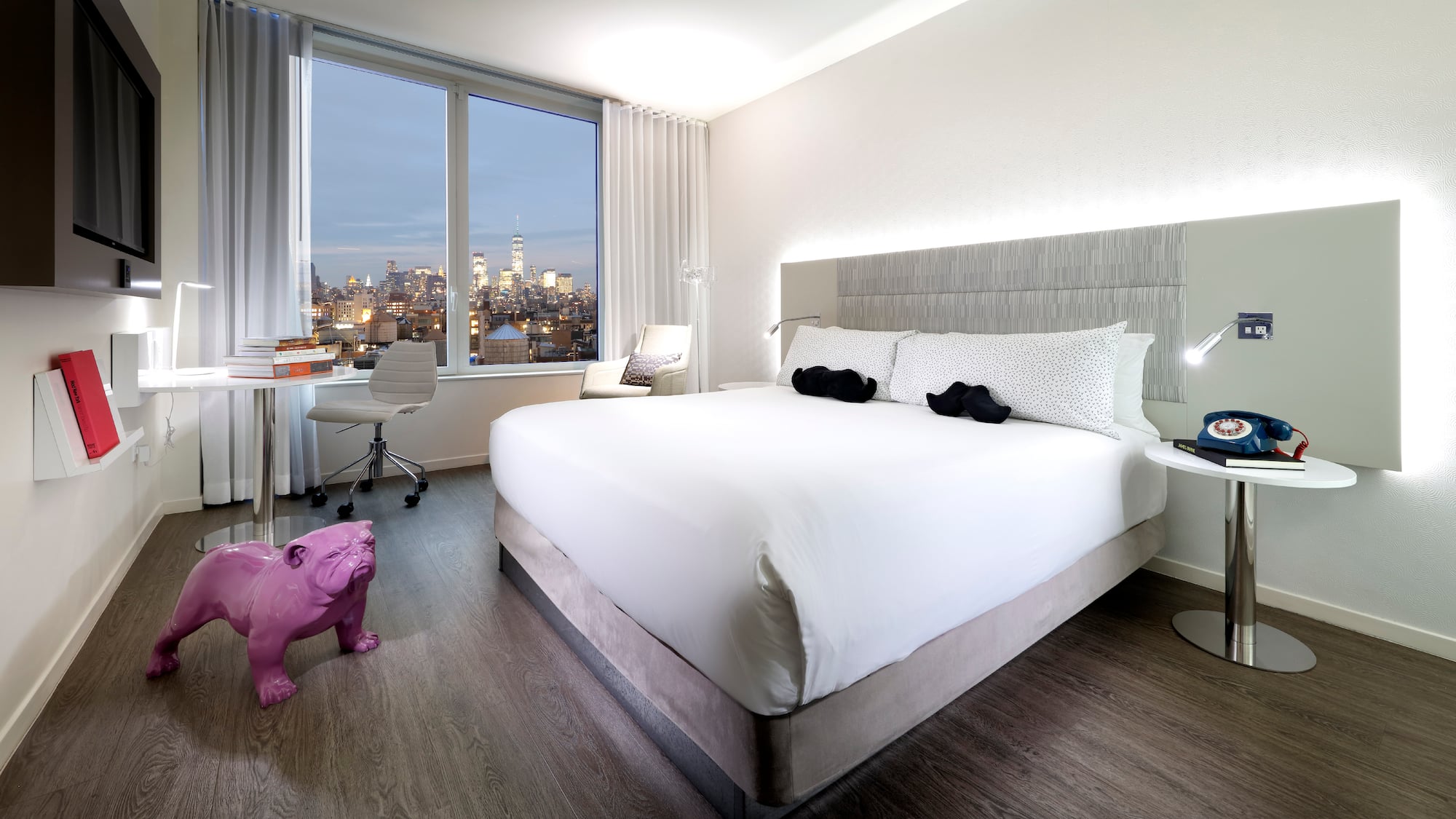 a bedroom with a large bed and a pink dog statue