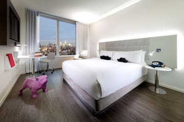 a bedroom with a large bed and a pink dog statue