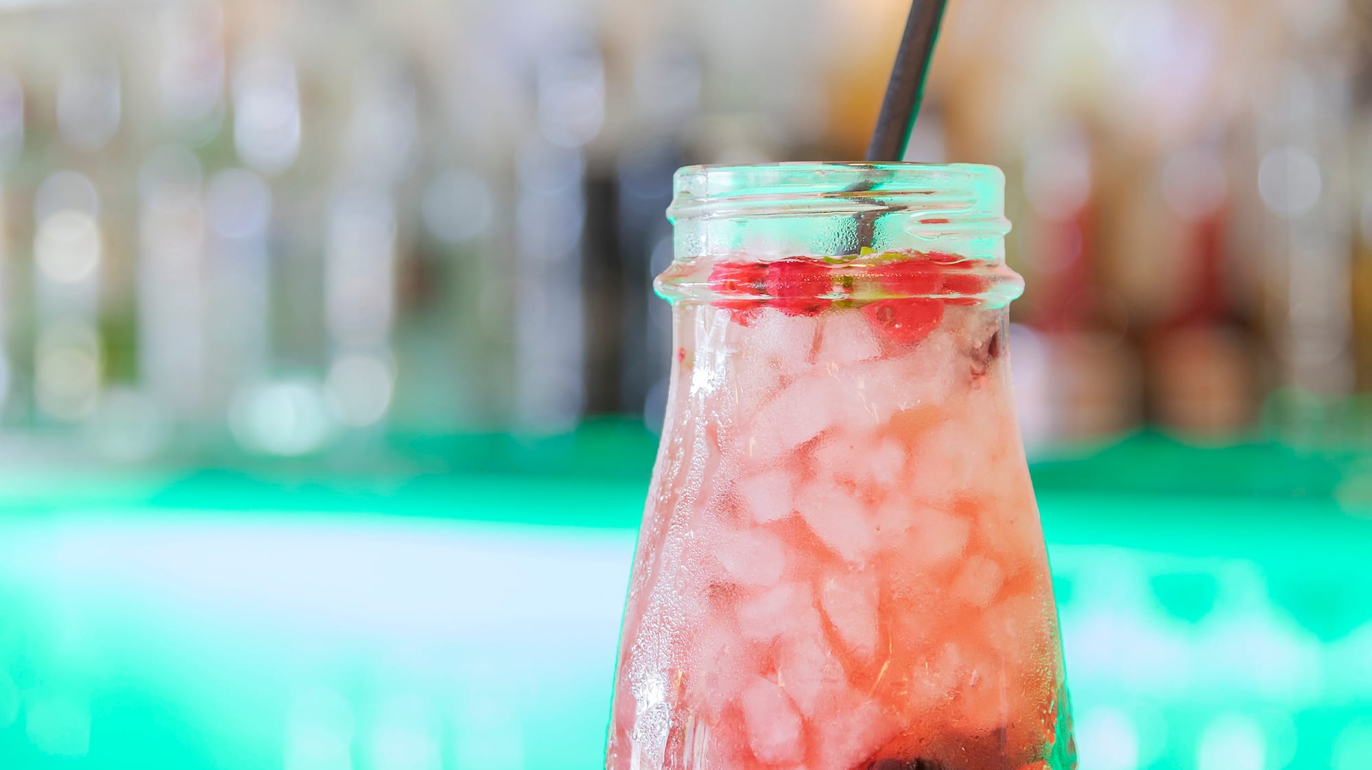a glass jar with a drink and a straw
