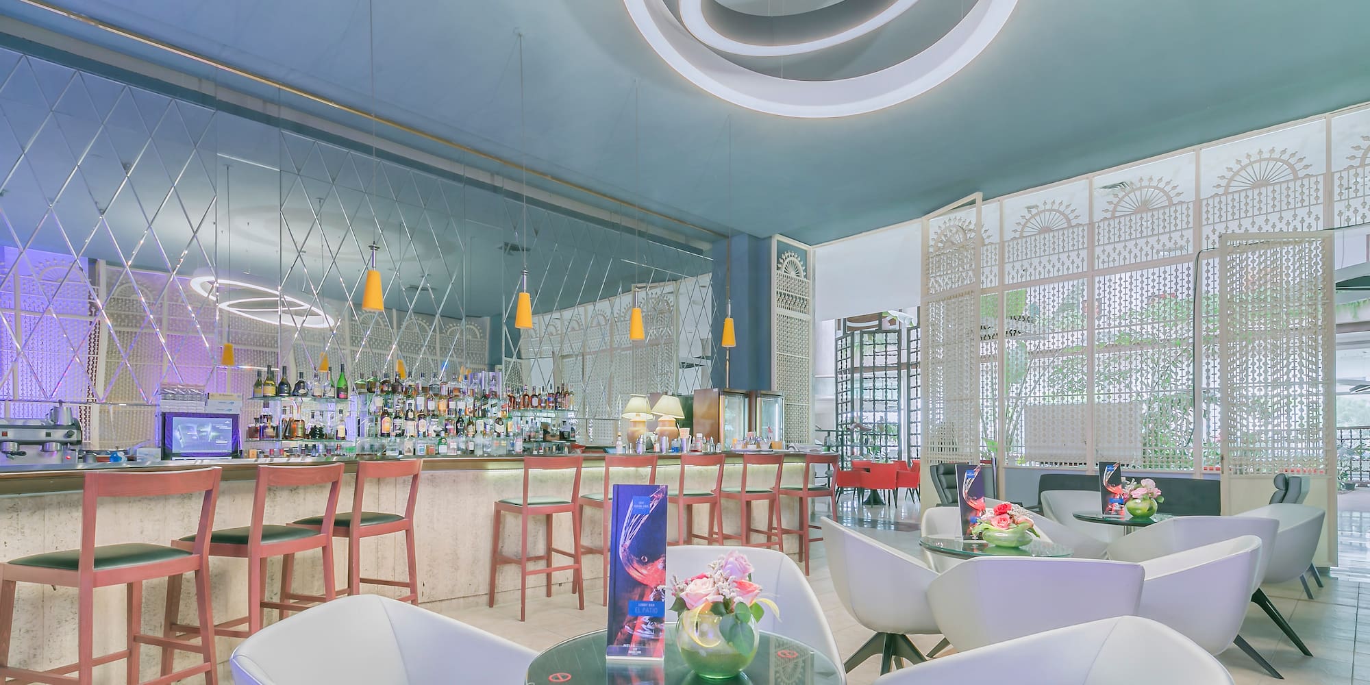 a bar with white chairs and tables