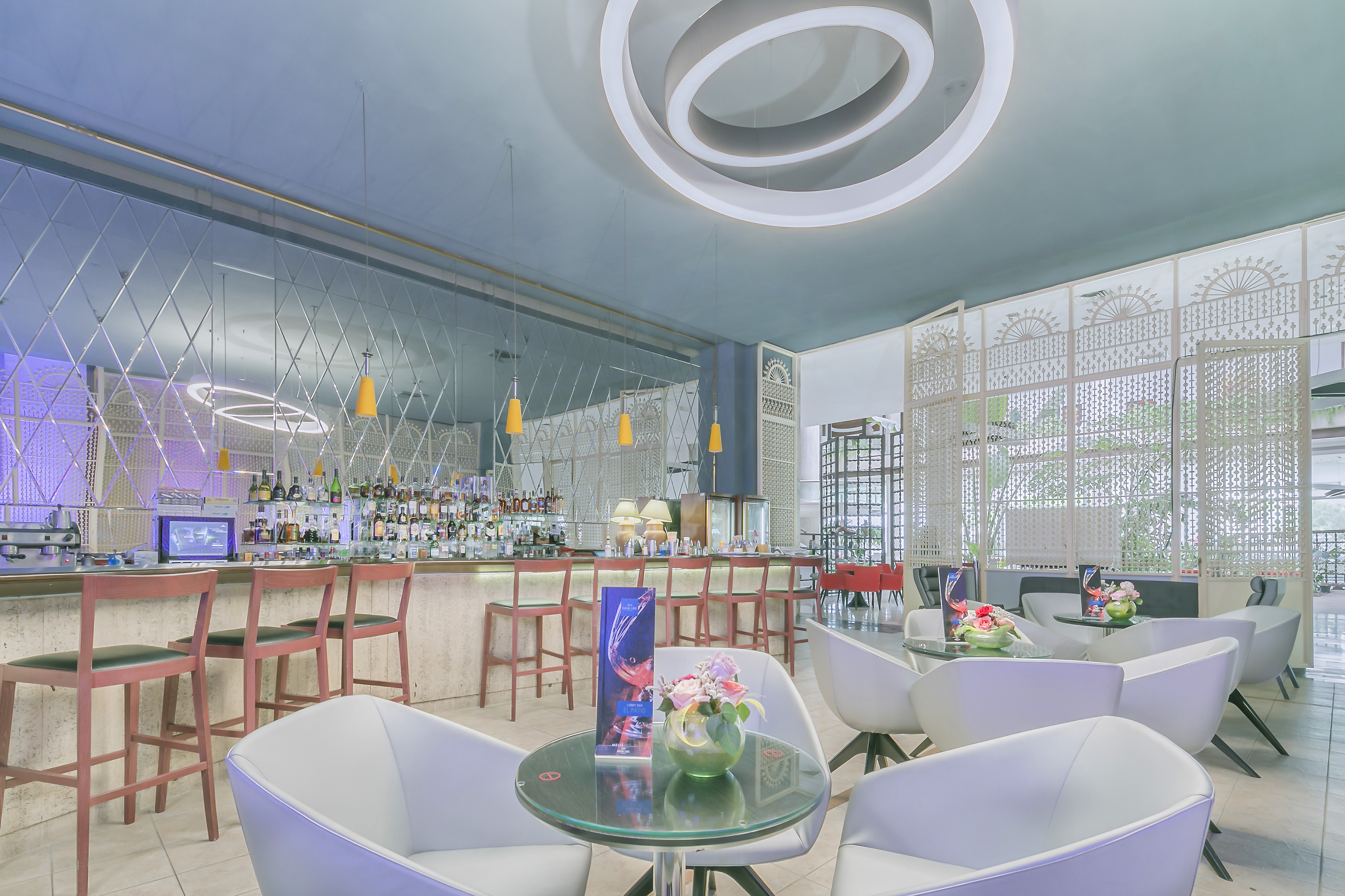 a bar with white chairs and tables