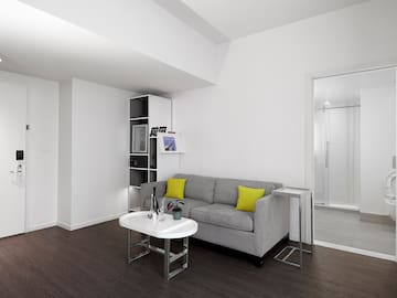 a living room with a grey couch and a white table