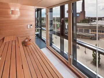 a wooden bench in a room with a view of a city