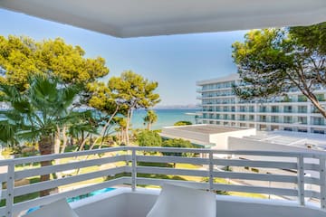 a balcony with trees and a body of water