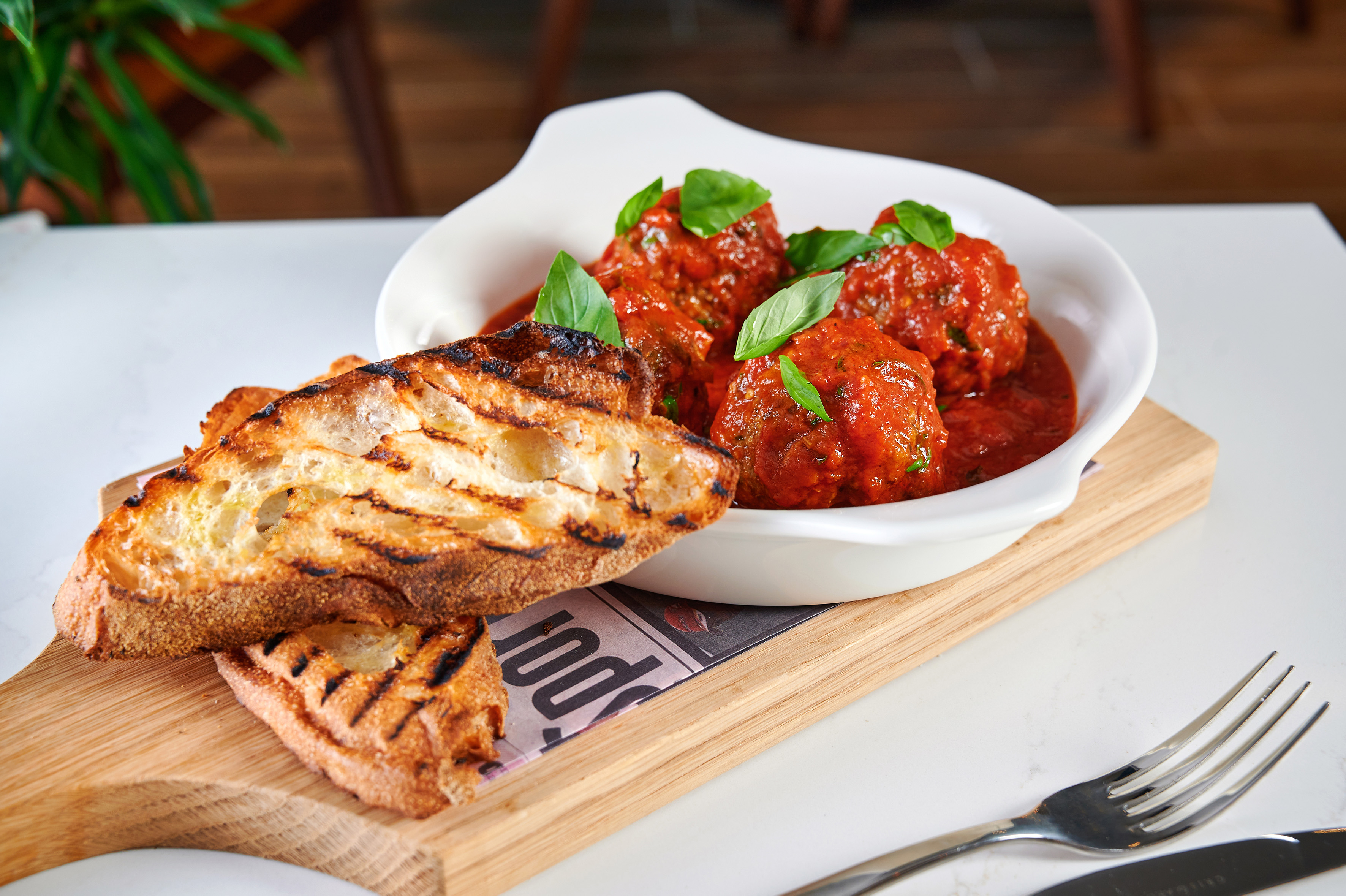 Italian meatballs in tomato sauce with basil, served with grilled bread.