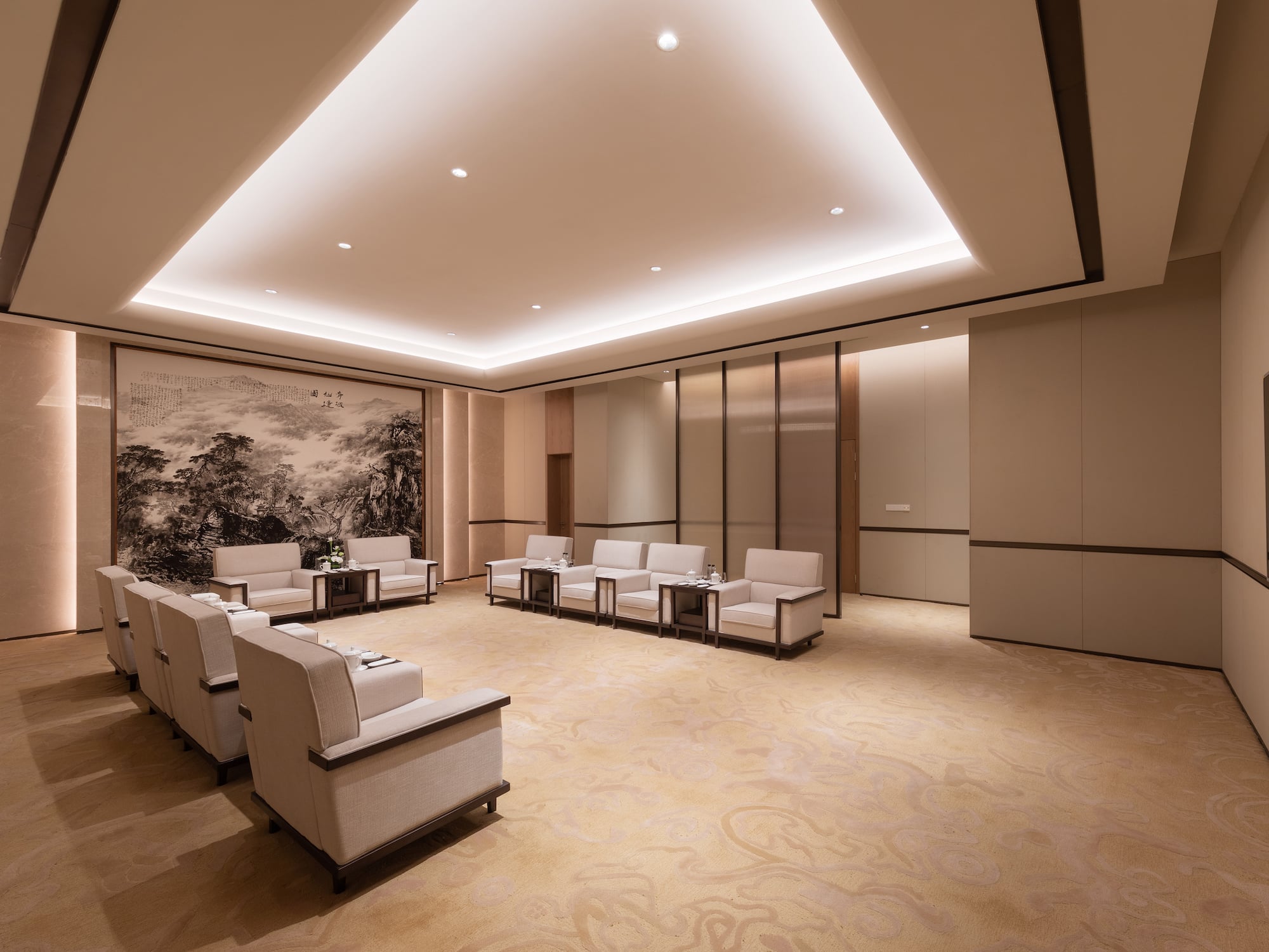 a room with white chairs and a painting on the wall