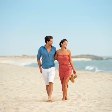 a man and woman walking on a beach