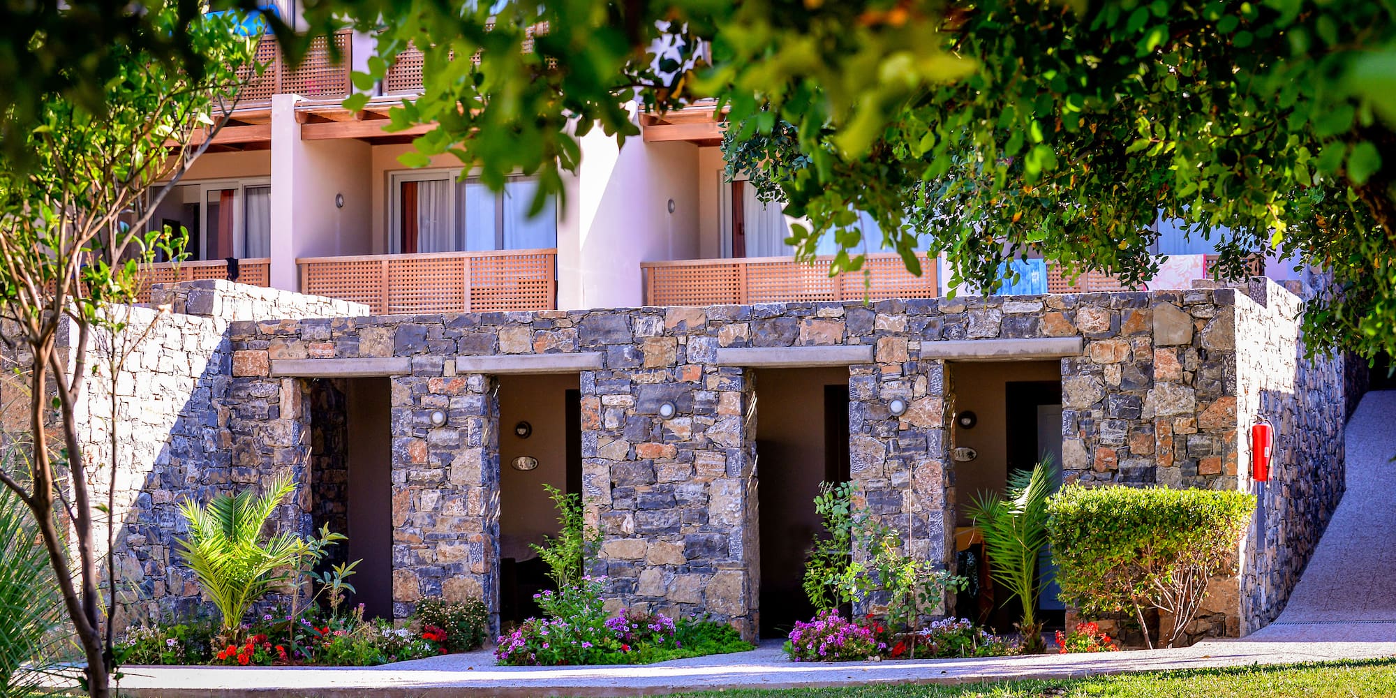 a stone building with many doors and plants