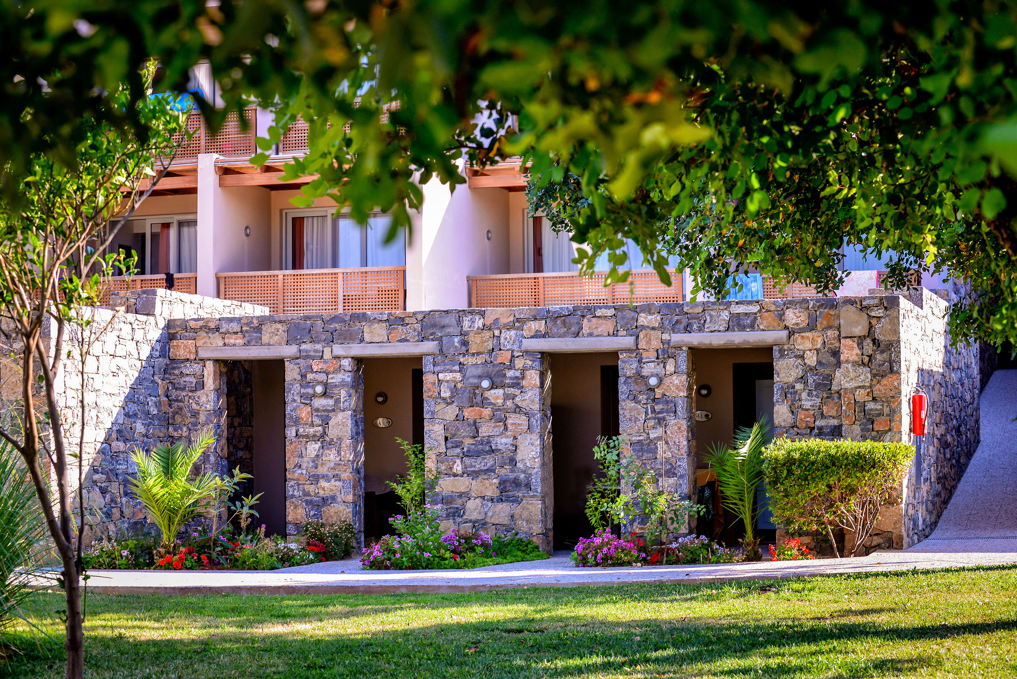 a stone building with many doors and plants