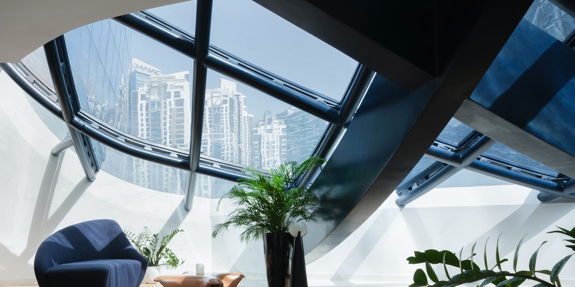 a room with a blue couch and a table and plants
