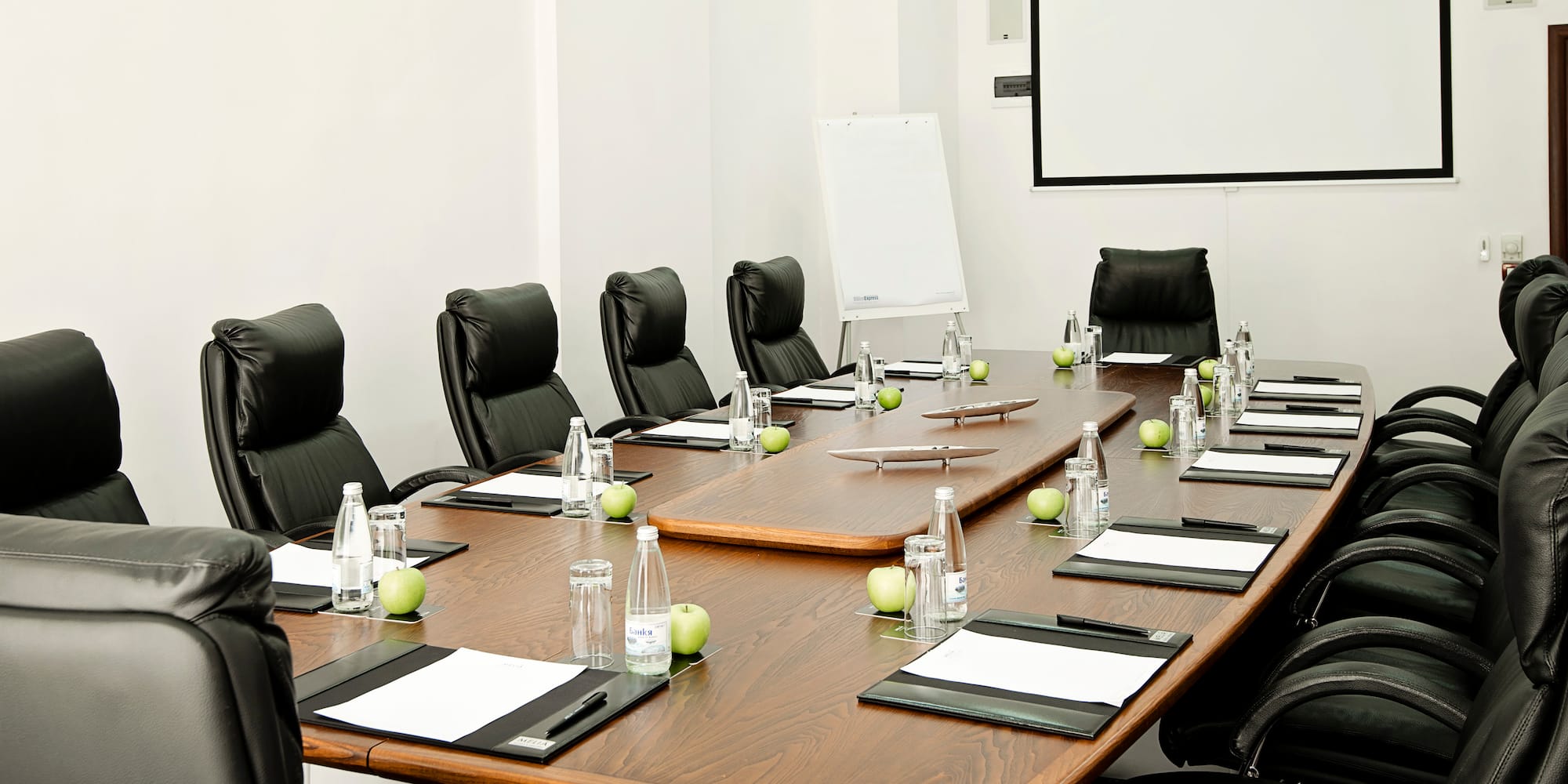 a conference room with chairs and a table with a white board
