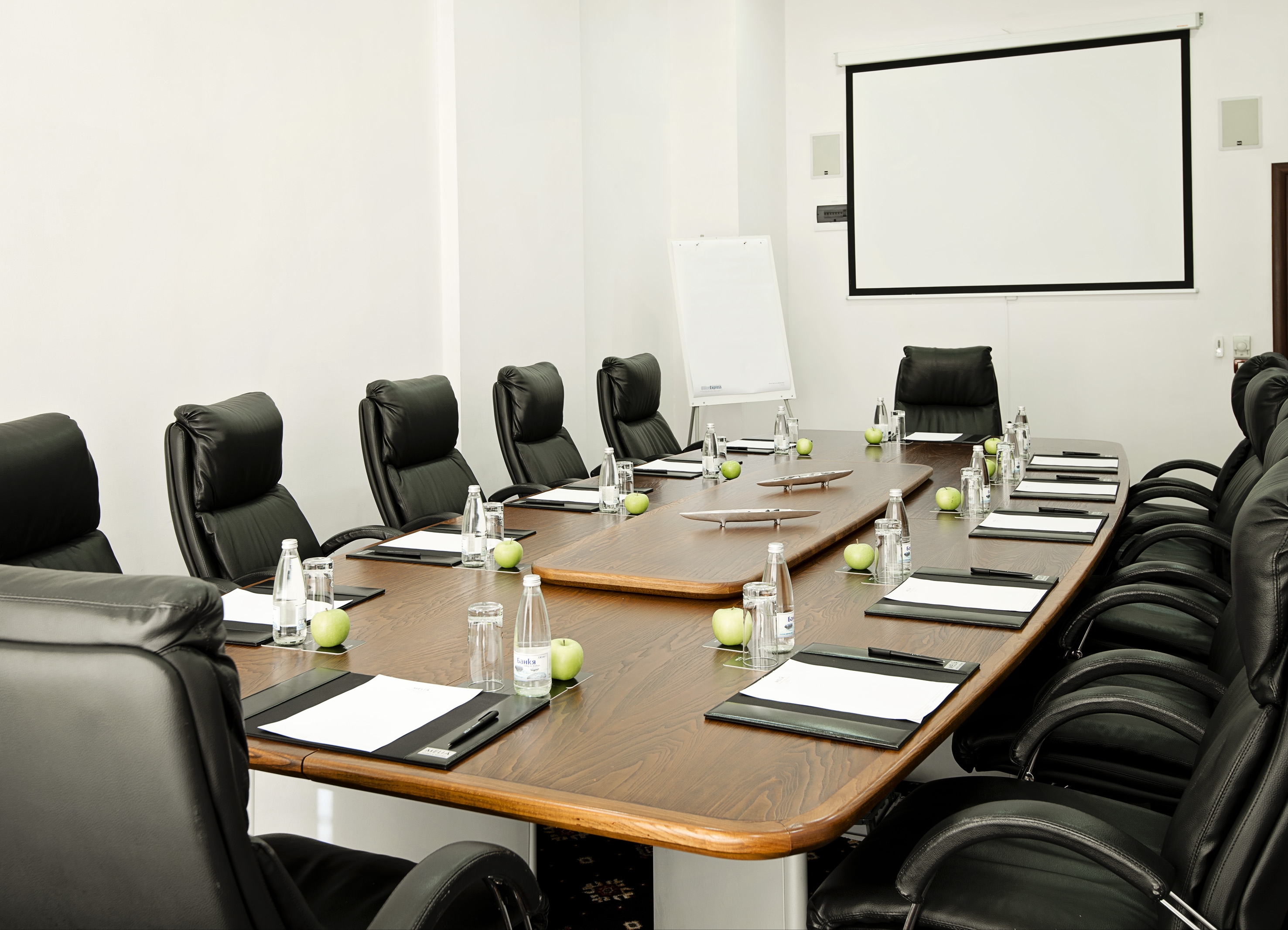 a conference room with chairs and a table with a white board