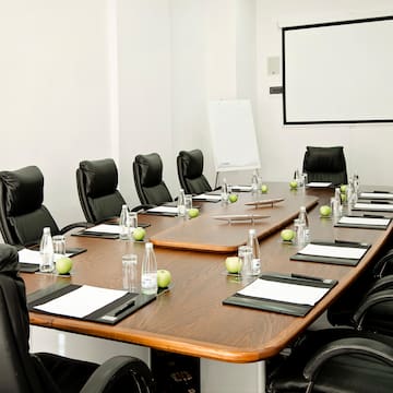 a conference room with chairs and a table with a white board
