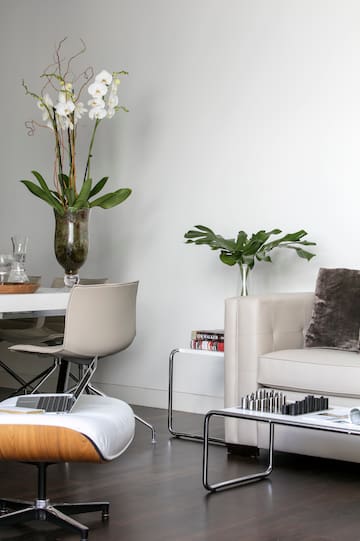 a white couch and a vase with flowers