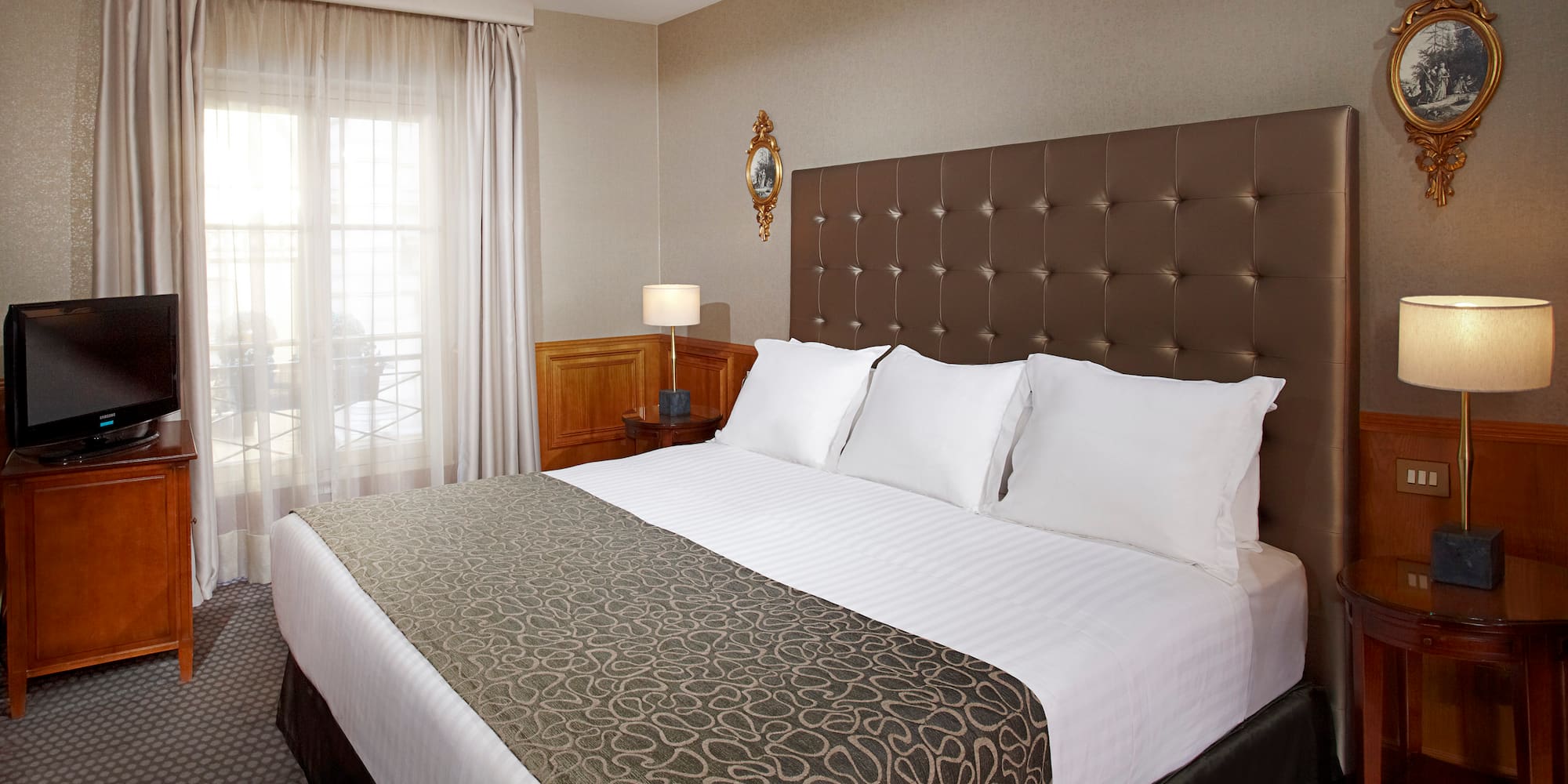 a bed with pillows and a lamp in a room