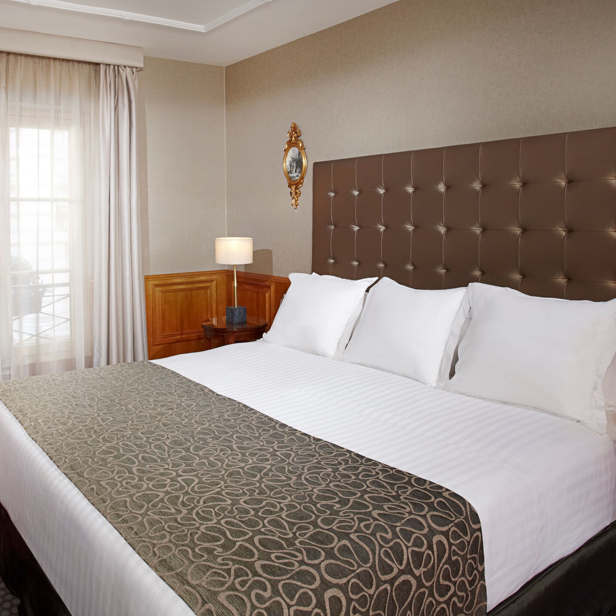 a bed with pillows and a lamp in a room