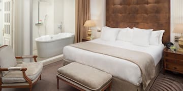 a bedroom with a large bed and a bathtub