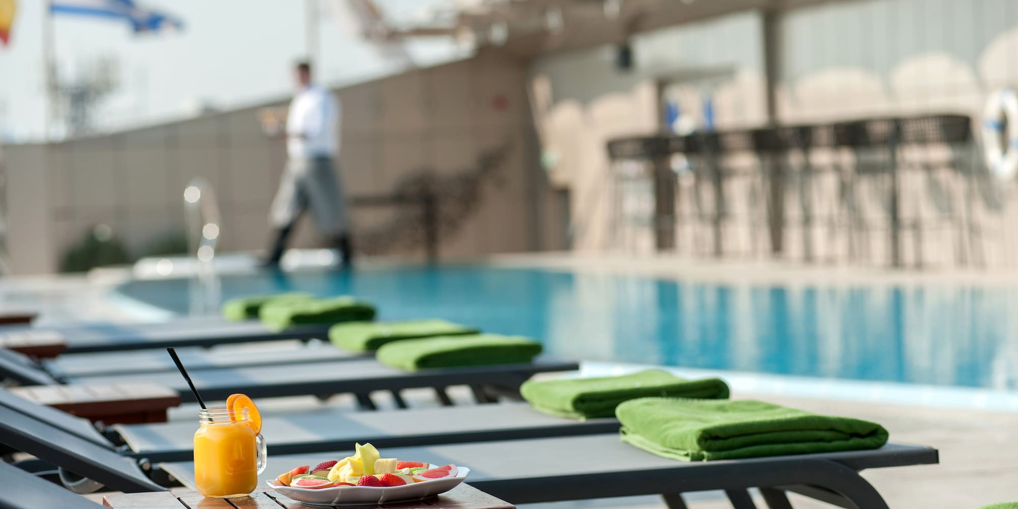a pool with a drink and a plate of food