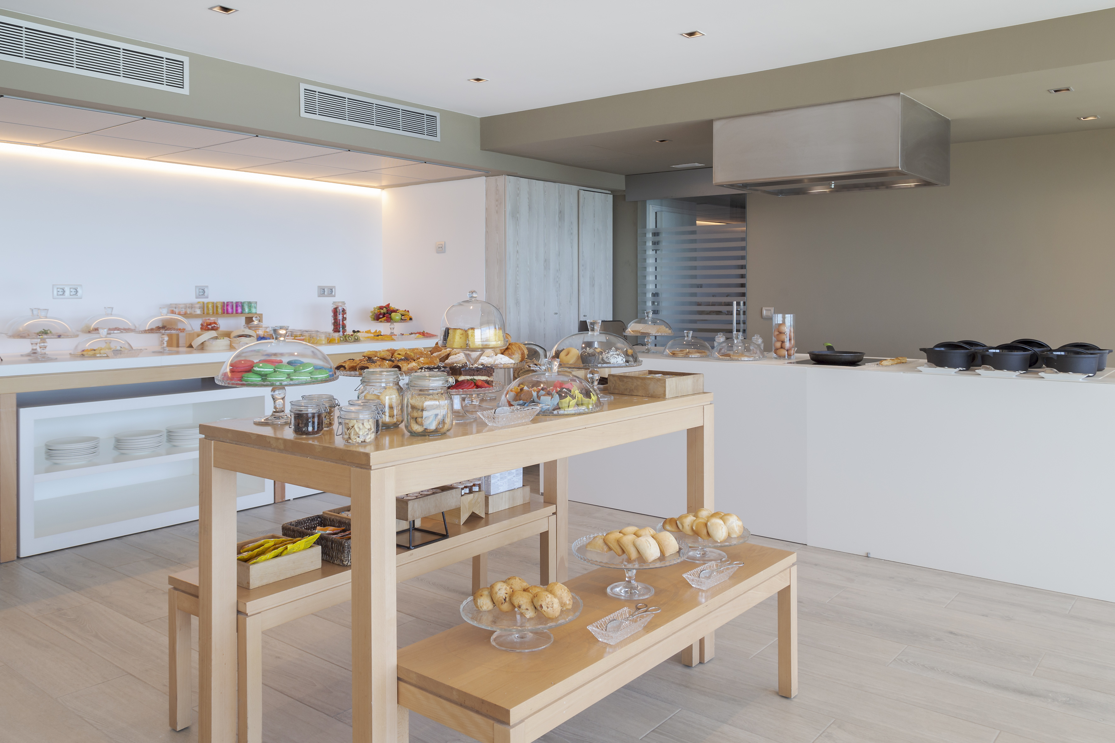 Modern hotel breakfast buffet with diverse pastries, fruits, and hot food.