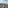 Panoramic Madrid cityscape with red tile rooftops, church spires, and blue sky.