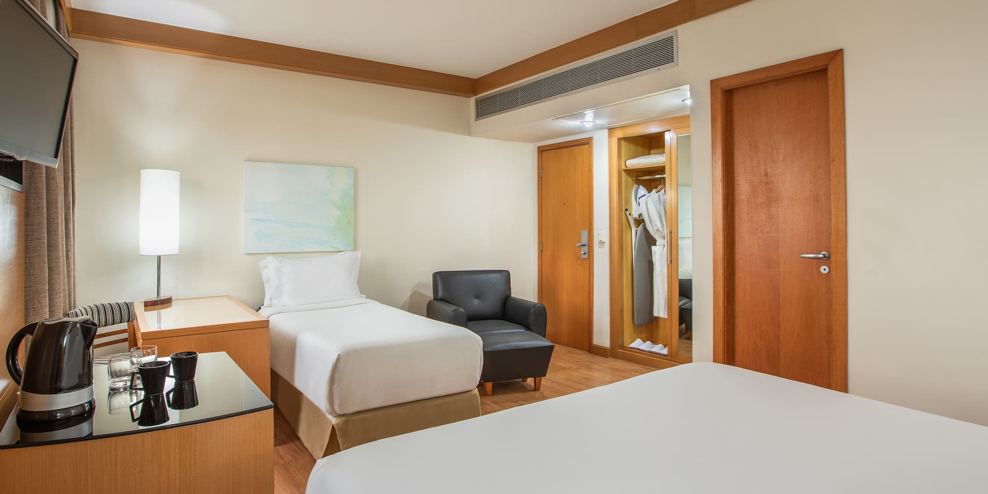 a room with two beds and a chair