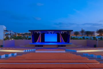 a stage with a blue screen and seats in front of it