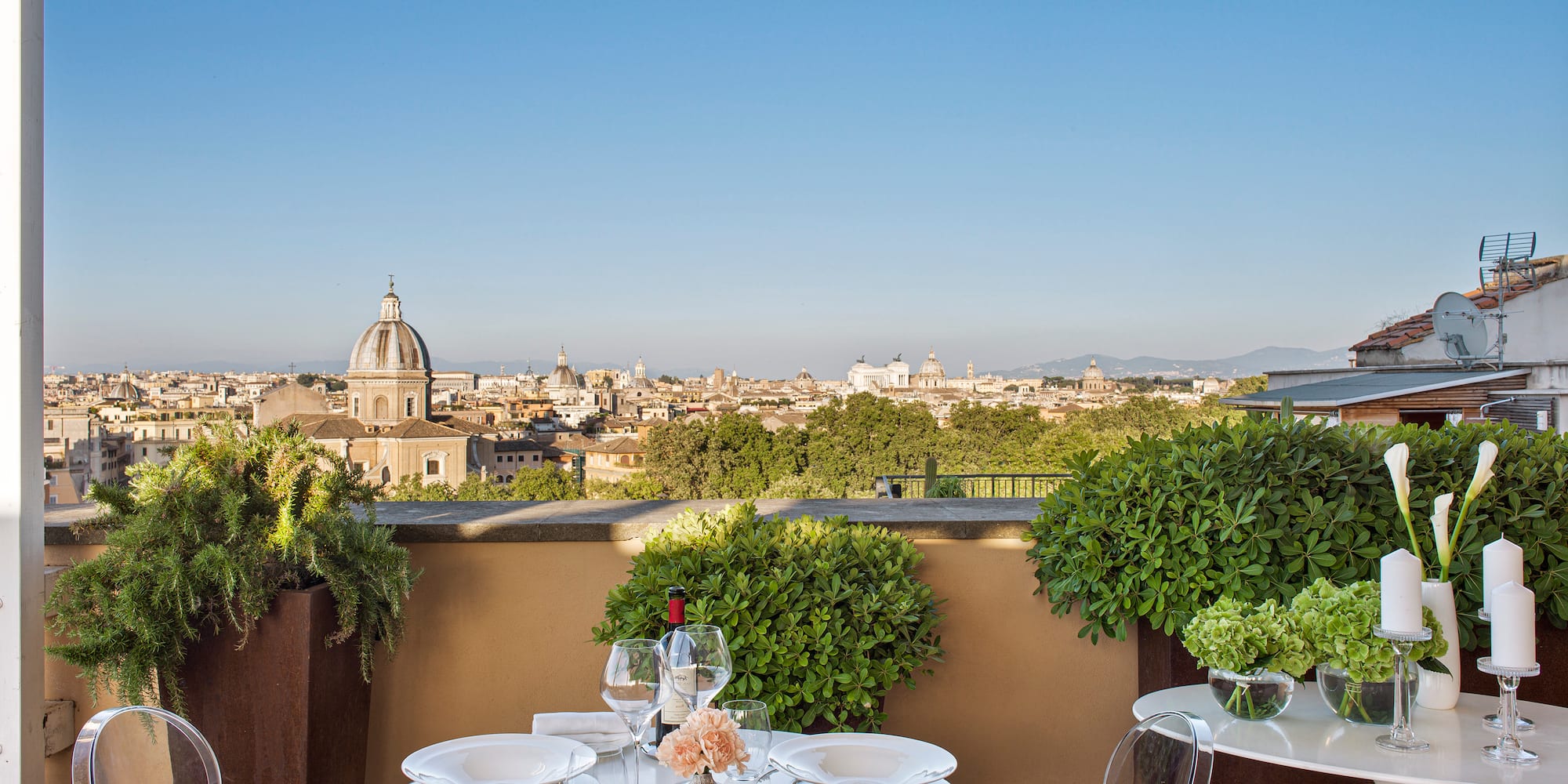 a table set up on a balcony with a city in the background